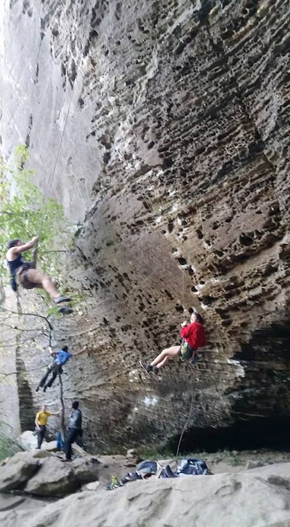 Three climbers hanging in the air away from the wall 
