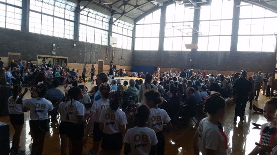 A crowd gathers in a gymnasium