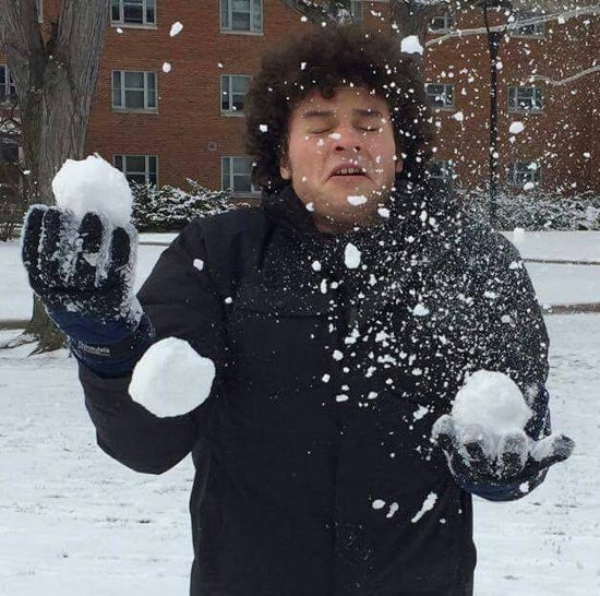 Someone mid-juggle of snow balls with a burst snow ball in front of their face