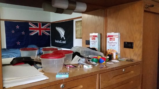 Empty food containers in front of a mirror reflecting the flag of New Zealand.