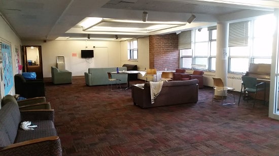 A spacious common area with couches and desks.