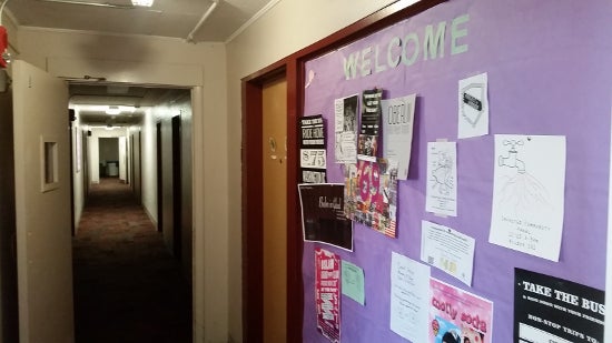 Bulletin board with 'Welcome' and many small posters.