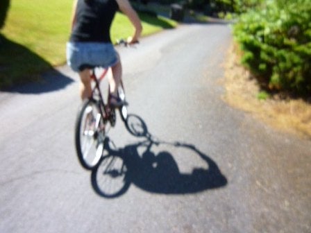 A blurry photo of a girl biking in the street
