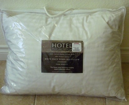 A pillow in its packaging with a TJ Maxx sticker. Brand name is Hotel.