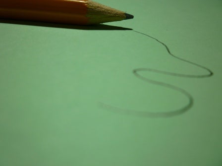 A pencil is laid down beside a squiggly line.