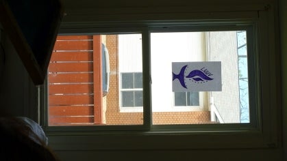 A window with a drawing of the LUUV logo 