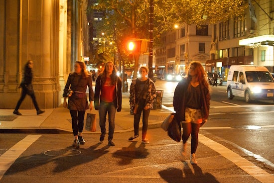 Four people walk through a crosswalk