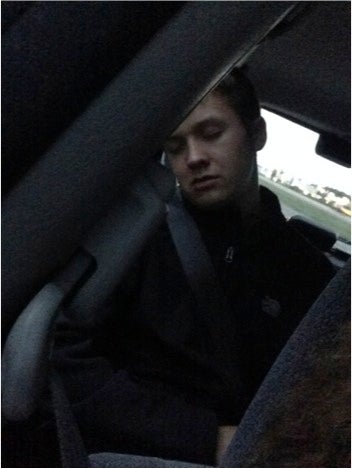 A student asleep in the backseat of a car