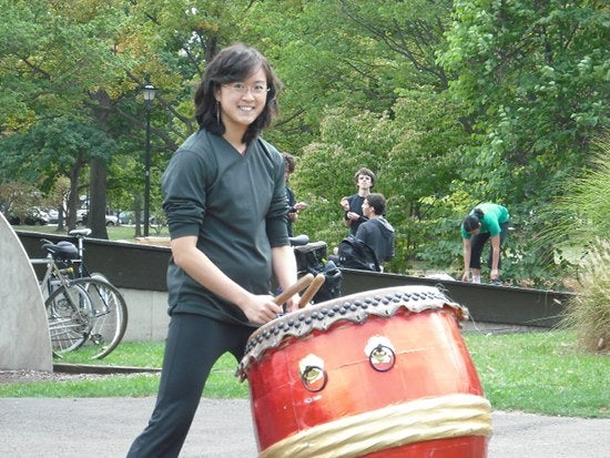 A drummer holds sticks ready above a Taiko drum.