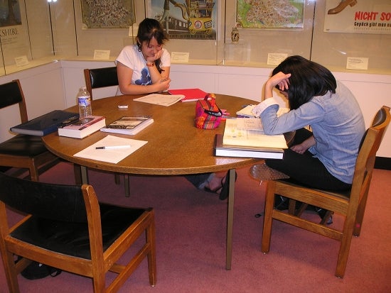 Two students sit at a table and read
