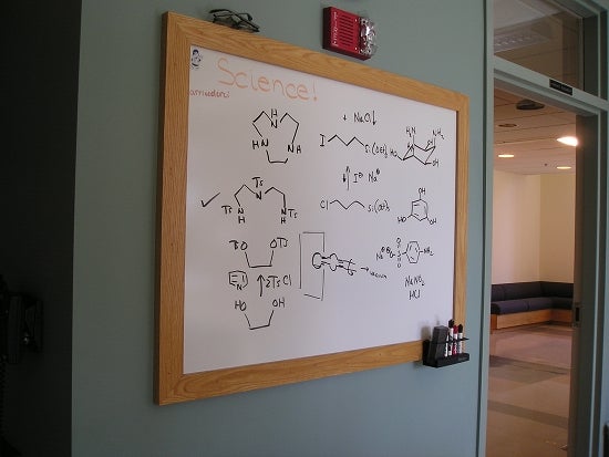 A whiteboard filled with scientific reactions