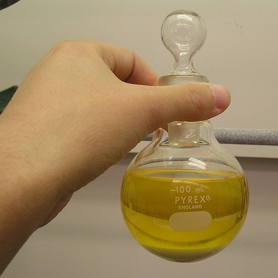 A measuring glass holding yellow liquid