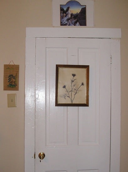 The door to the outside with a picture of flowers hanging