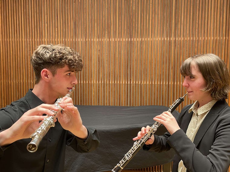Myself and oboist Chiara Rackerby on stage in Kulas Recital Hall facing each other menacingly whilst holding our instruments.