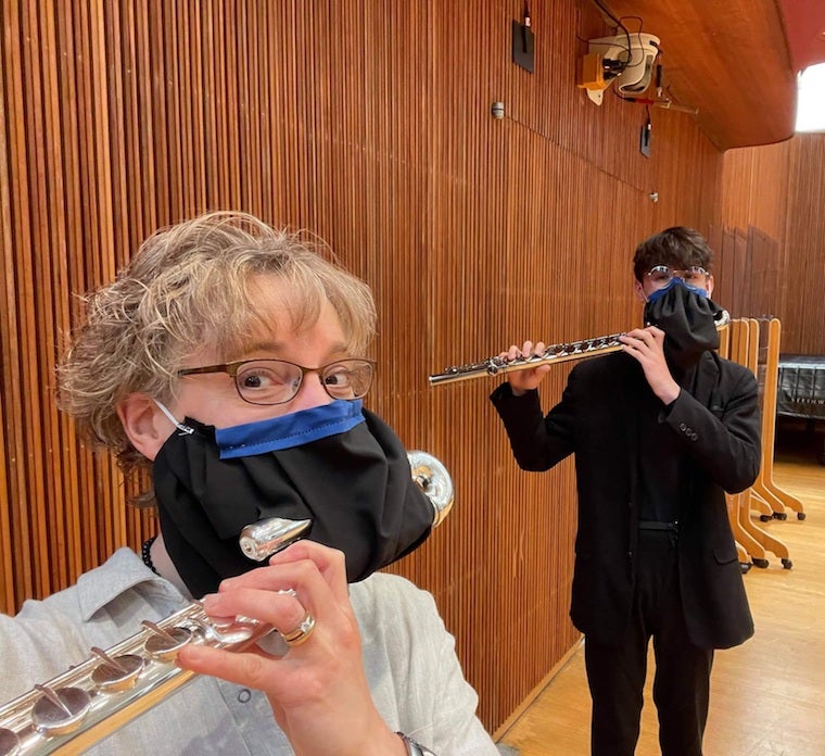 Professor Kelly Mollnow-Wilson and I holding alto flutes while wearing custom flute masks as part of the COVID-19 regulations.