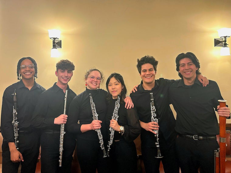 All of the woodwinds who played in Mendelssohn's Symphony No. 3 smiling holding instruments in the basement of Finney Chapel. 