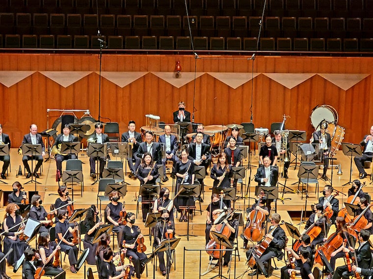 A picture of the Seoul Philharmonic Orchestra musicians (woodwind section) standing on stage to receive applause after their performance.
