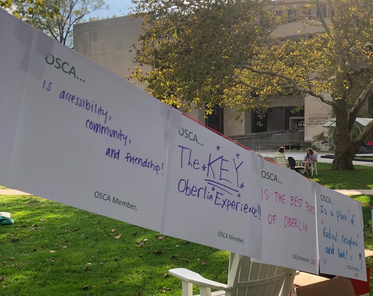 Papers with the text "OSCA..." with various responses written such as "is accessibility, community, and friendship!" "The KEY Oberlin Experience!!" and more.