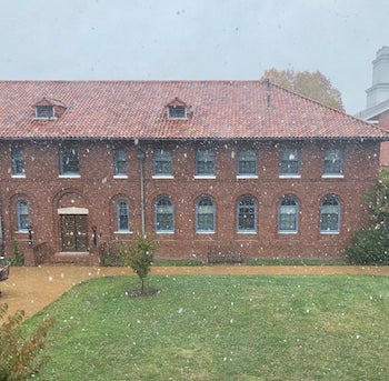 Red brick building with snow falling 