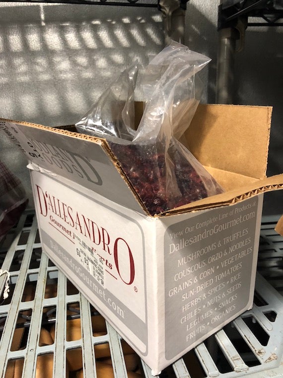 A box filled with dried cranberries, sitting on a shelf in a fridge
