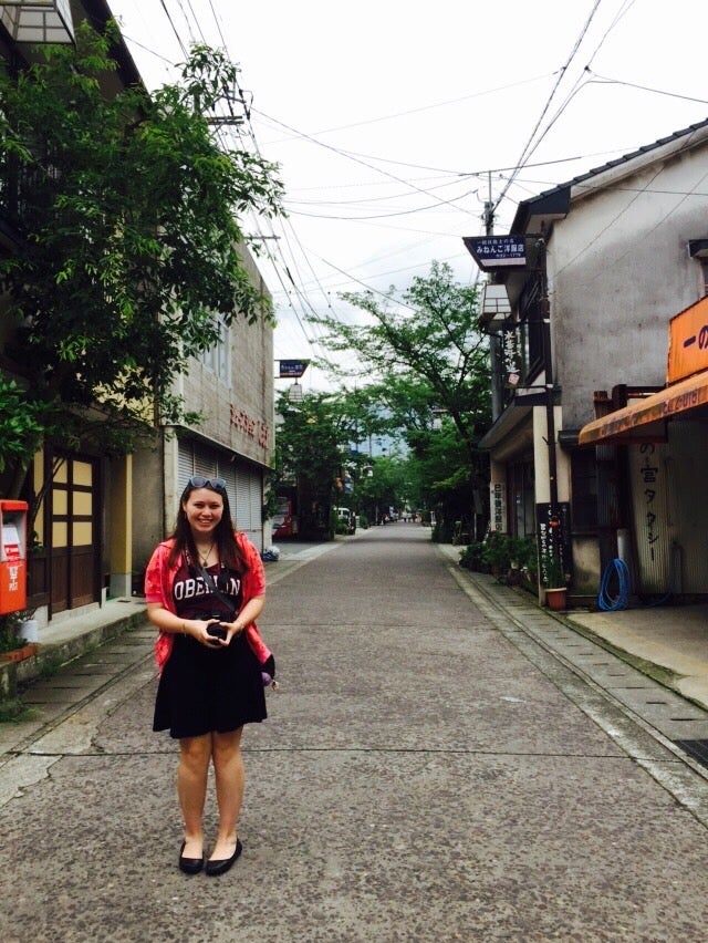Cora wearing an Oberlin shirt on a street in Japan.