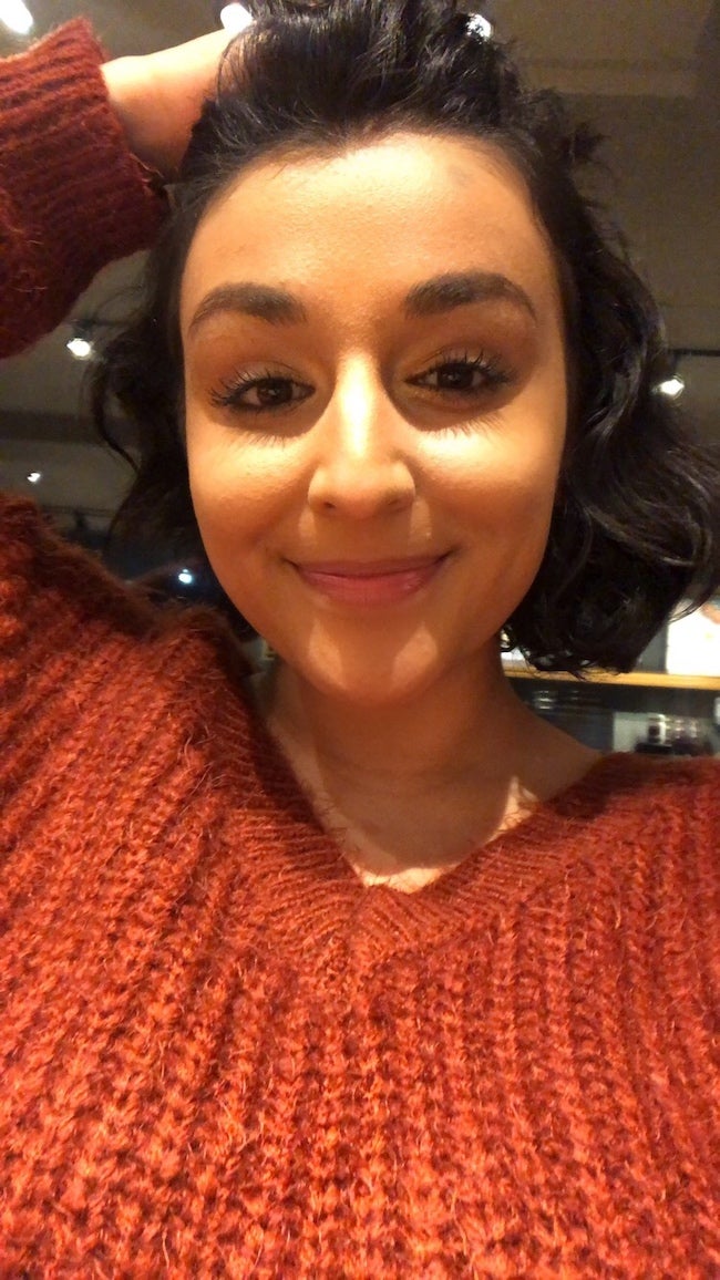 miranda with short black hair and a red-orange cable knit sweater