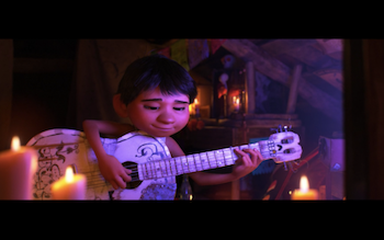 Miguel from Coco strumming his guitar with a content look on his face.