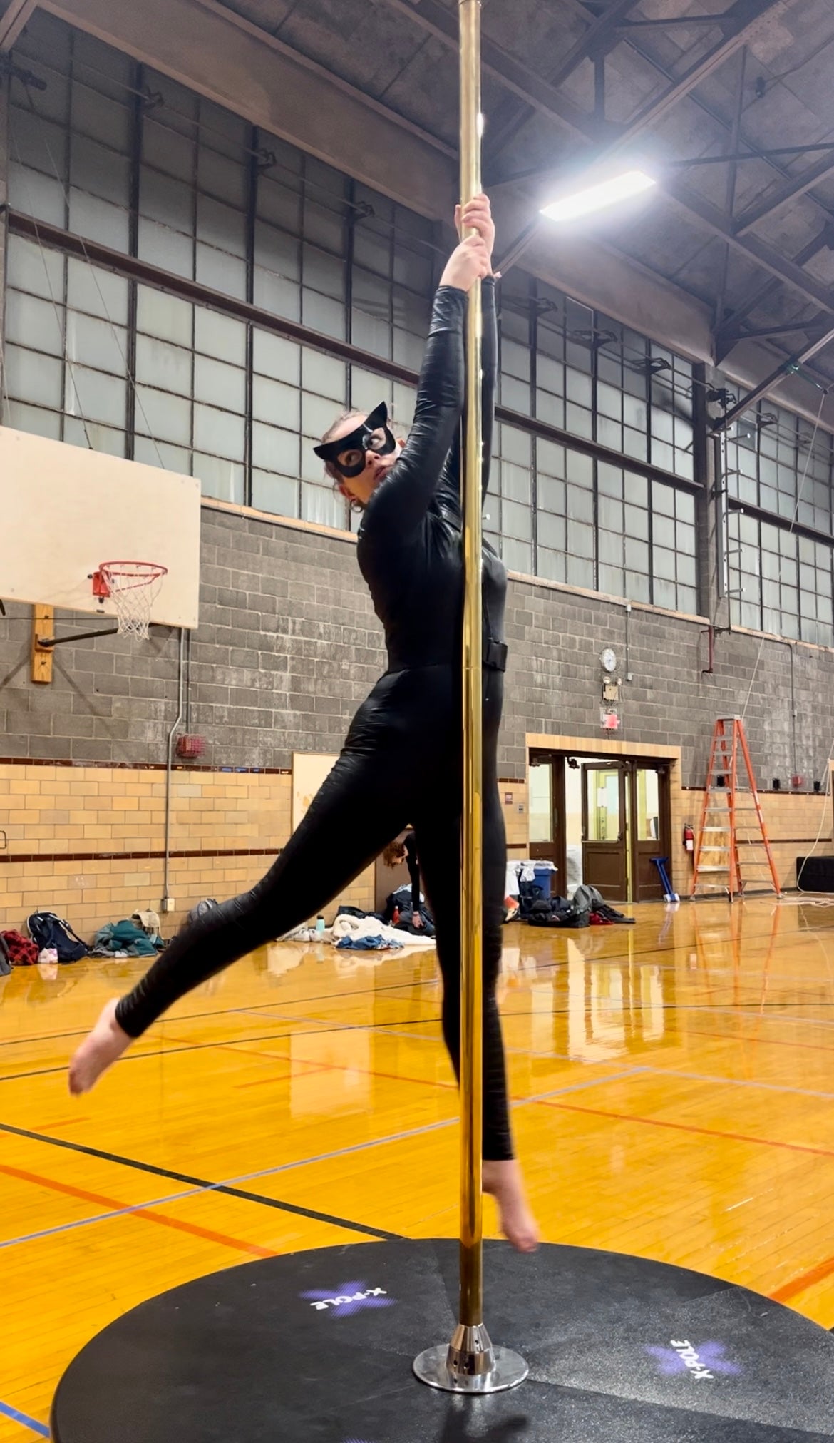Natalie dancing on the pole in a Catwoman costume