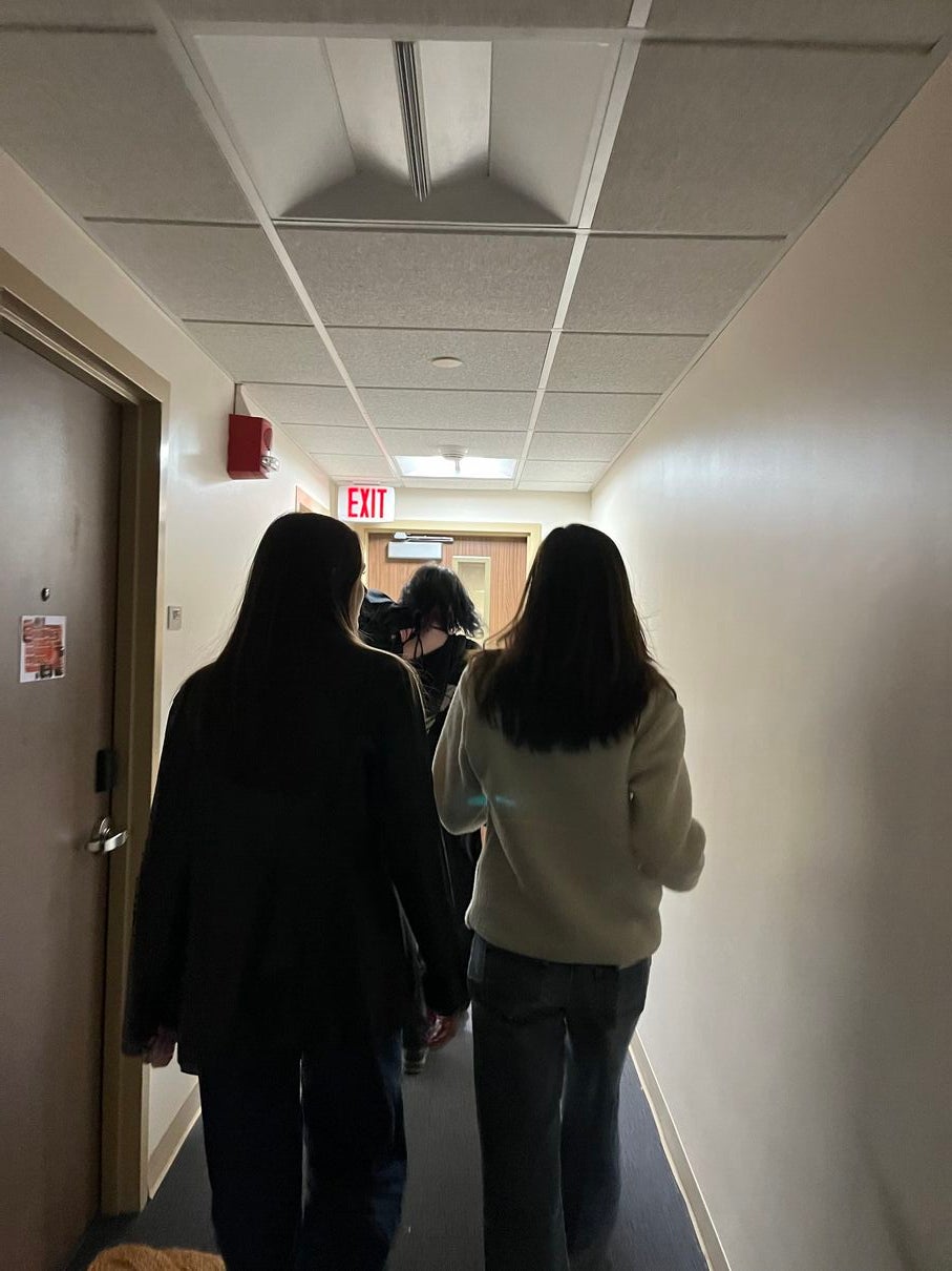 Julia, Addie, and Calista walking down a dark hallway