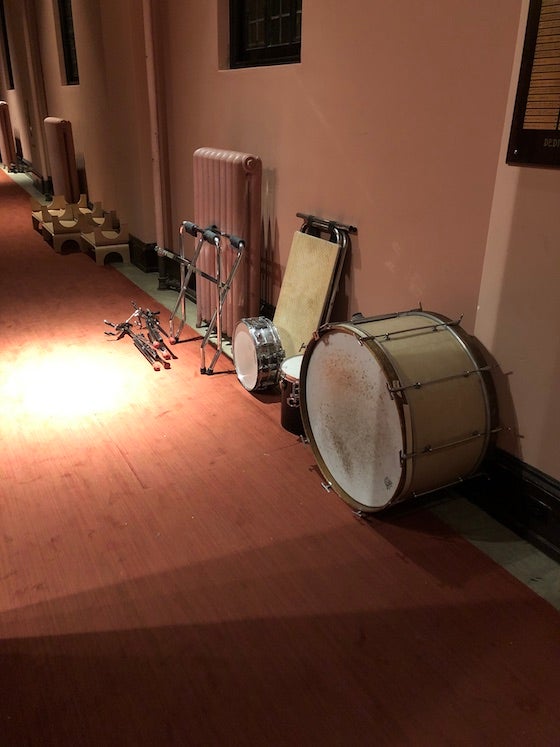 Drums, stands, stacked against the wall of Finney Chapel.