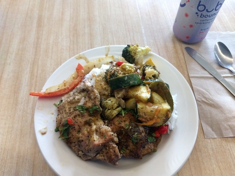 A plate of thai green curry chicken and stir-fried vegetables