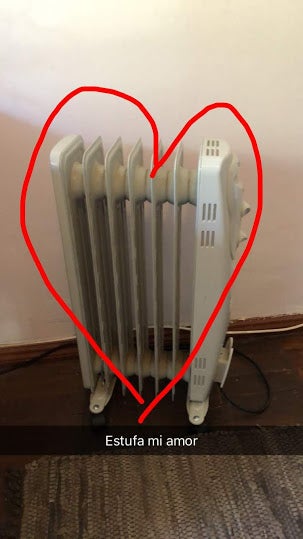 a photo of a small space heater with a heart drawn around it and the caption written across "estufa mi amor"