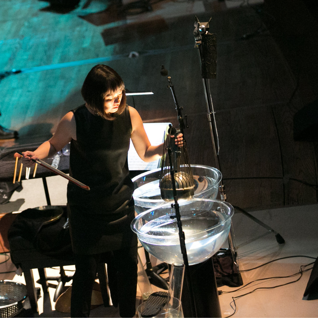 Asian woman playing unique percussion instruments