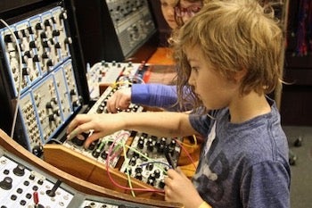 children working with vintage synthesizers
