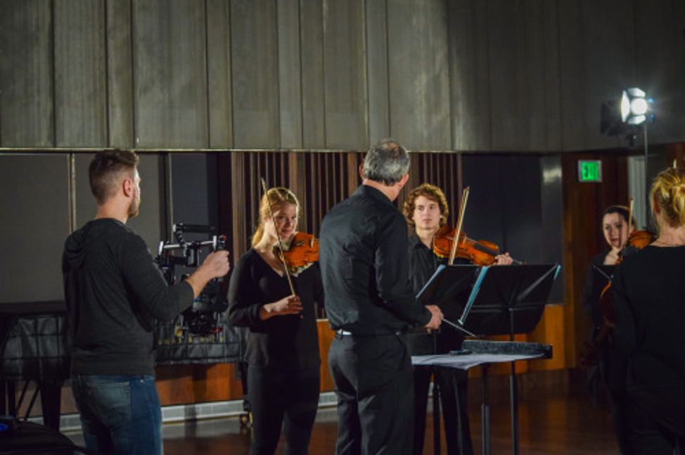 Musicians and their conductor in a studio.
