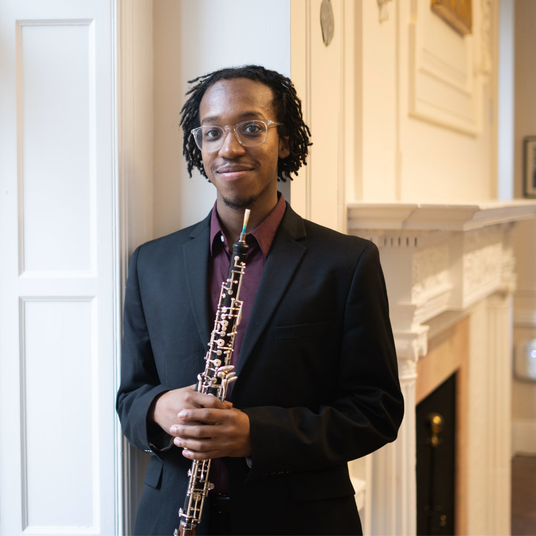 young person standing by a window, holding an oboe