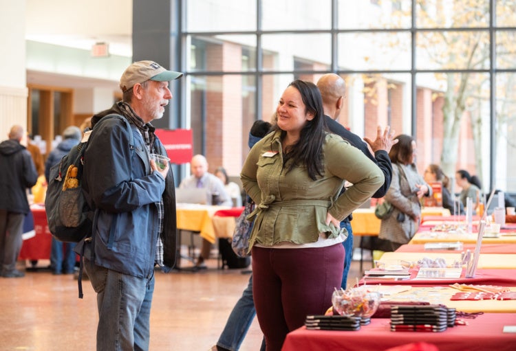 Staff member chats with table visitor