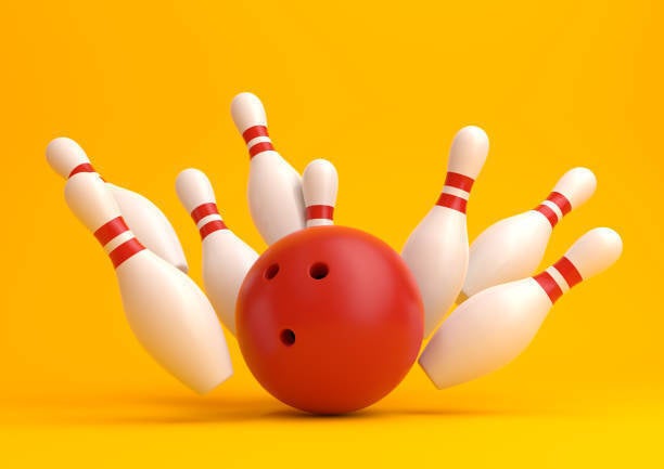 red bowling ball smashing into eight bowling pins