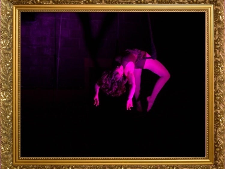 Aerial performer in pink lighting