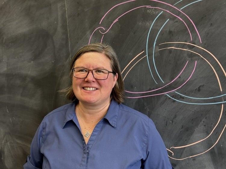 Headshot of Shelly Harvey in front of knots on chalkboard
