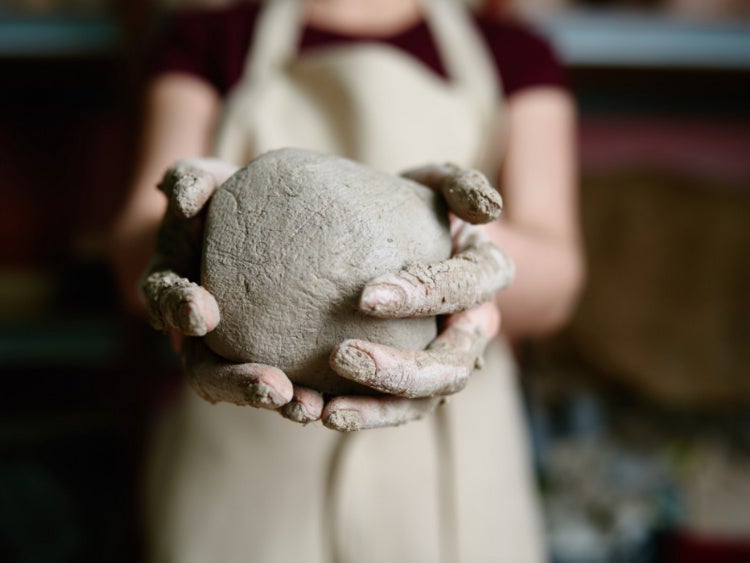 person holding clay