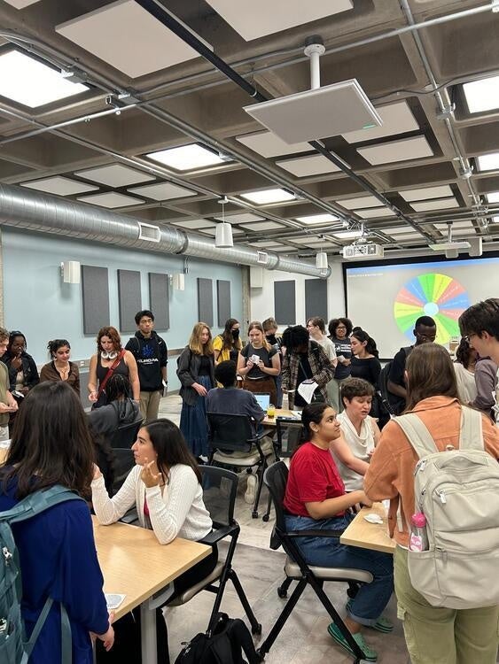 Room full of students engaging in conversation