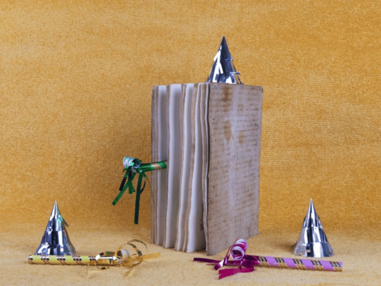 old book with birthday party favors around it