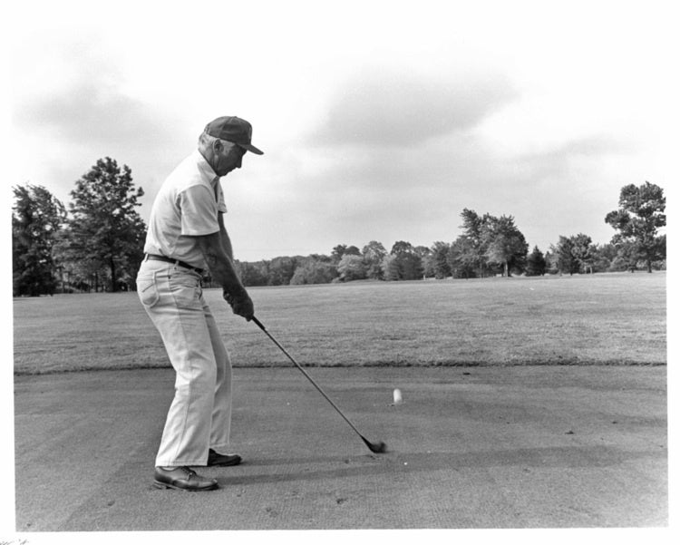 A golfer drives the ball at the tee. Undated black & white archive photo.