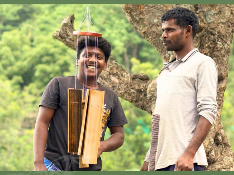 Two people outside, looking at a wind chime