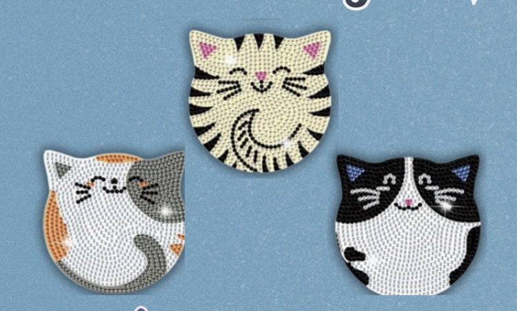 Three round stylized shiny cat coasters: one calico, one tabby, and one black and white cat.