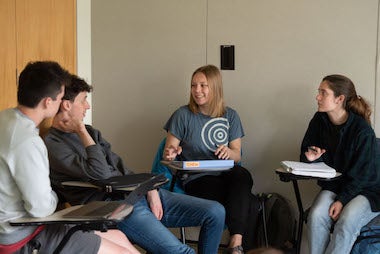 students sitting in semi circle in chairs