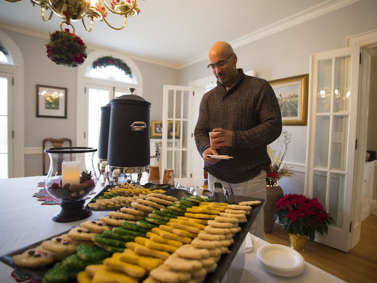 A staff member holds a plate of cookies.