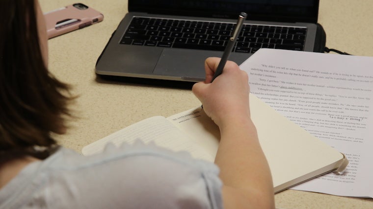 Image of a student writing in notebook