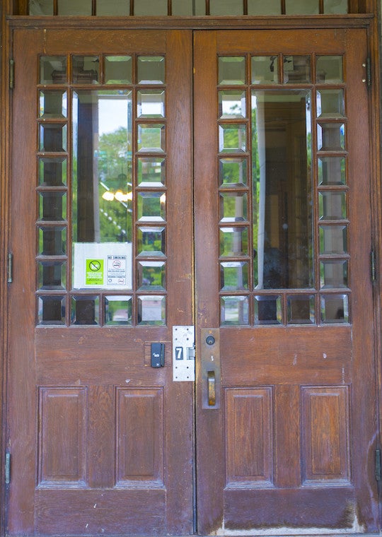 Double wooden doors with glass squares surrounding large glass panes